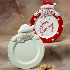 there is a plate with a cookie on it next to a snowman ornament