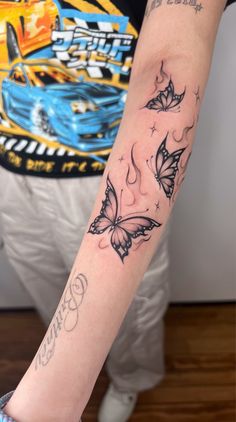 a woman's arm with tattoos on it and butterflies in the middle of her arm