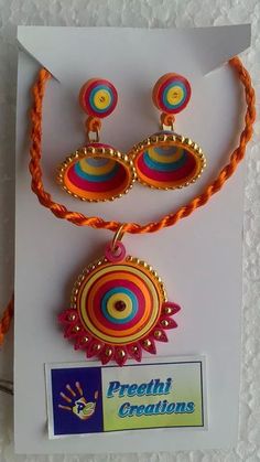 the necklace and earrings are on display in front of a white card with an orange string