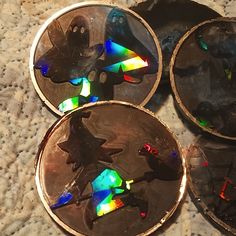 three metal discs with colorful holographics on them sitting on a counter top