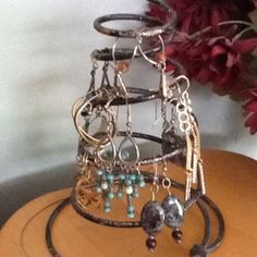 a bunch of bracelets that are sitting on a table next to a vase with flowers in it