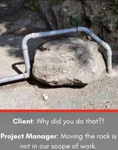 a large rock sitting on top of a dirt ground next to a metal pipe that is attached to it