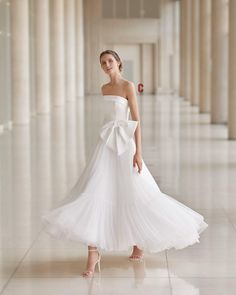 a woman in a white dress standing on the floor