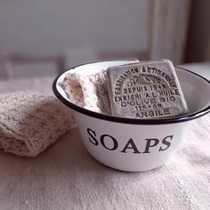 a white bowl with soaps in it sitting on a table next to a towel