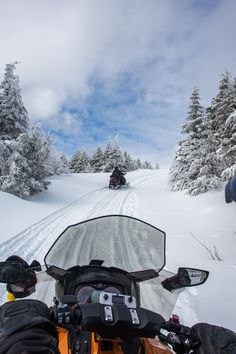 two people riding motorcycles on a snowy road