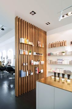 the inside of a hair salon with wooden shelves and shelvings on the wall