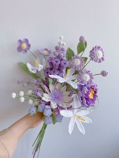 a person holding a bouquet of flowers in their hand