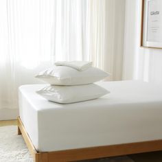 three pillows stacked on top of each other on a bed