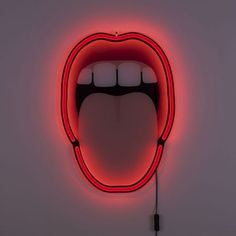 a neon sign with an open mouth on it's side in the shape of a tongue