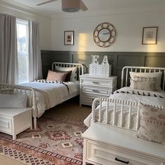 a bedroom with two twin beds and a rug on the floor in front of a window