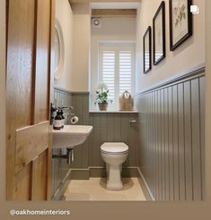 a white toilet sitting next to a sink in a bathroom under three framed pictures on the wall