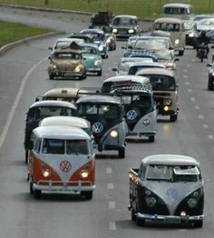 several vw buses driving down the road in traffic