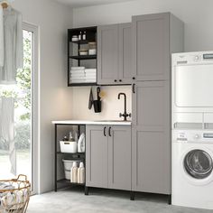 a washer, dryer and cabinets in a small room with open doors to the outside