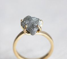 a gold ring with a rough diamond on it