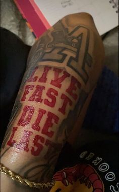 a man with tattoos on his arm and leg, has the words live fast die slow written in red ink