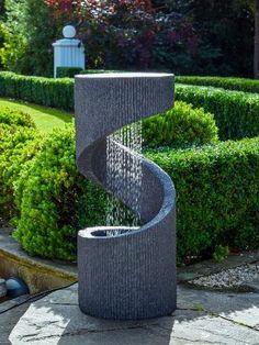 a water fountain in the middle of a garden