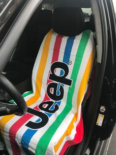 an open car door with a colorful blanket on the back seat in front of it