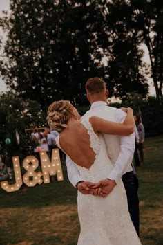 a bride and groom embrace in front of the j & m sign