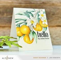 a greeting card with lemons and daffodils on it, sitting next to a potted plant