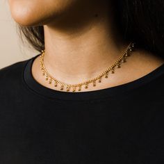 Our best-selling dangling dotted choker features an evenly spaced array of spherical dotted charms that deliver a minimal and elegant aesthetic to your wardrobe meant for essential everyday wear. Materials & Warranty Material: Real 18 Karat Gold Plating on pure stainless steel Length: 13 inches with a built-in 3 inch extension (16 inches total) Hypoallergenic | Sensitive Skin-Friendly Waterproof | Keep it on in the shower Warranty: Lifetime Warranty against all rust or tarnish Packaging: Nominal Adjustable Ball Chain Necklaces, Everyday Tiny Beads Choker, Adjustable Dangling Beads Choker, Adjustable Charm Necklaces With Tiny Beads, Elegant Aesthetic, Everyday Necklace, Drawstring Pouch, Gold Plated Silver, Ring Bracelet