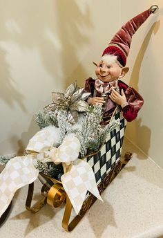 a trolly doll sitting on top of a sleigh filled with christmas decorations