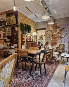 a room filled with lots of tables and chairs next to a wall covered in pictures