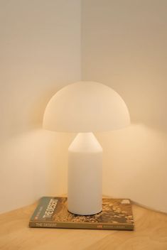 a white lamp sitting on top of a wooden table