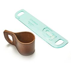 a brown leather cup holder next to a green plastic bottle opener on a white background