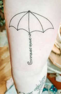 a person with a tattoo on their leg that has an umbrella and the words, i cannot't stand under it