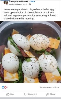 a plastic bowl filled with eggs and bacon on top of lettuce next to cheese