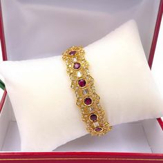 For Sale on 1stDibs - Ruby & Diamond Bracelet Style: Intricate Floral Filigree link Metal: 18K Yellow Gold, 30.31 grams Size & Measurements: 7'' long x 0.65'' (16.3 mm) wide Luxury Gold-plated Diamond Wedding Bracelet, Elegant Gold Ruby Bracelets, Elegant Gold Bracelets With Ruby, Yellow Gold Gemstone Tennis Bracelet For Wedding, Yellow Gold Tennis Bracelet With Gemstones For Wedding, Gold Ruby Tennis Bracelet As A Gift, Gold Ruby Tennis Bracelet Gift, Luxury 22k Gold Bracelet For Anniversary, Formal Yellow Gold Ruby Bangle