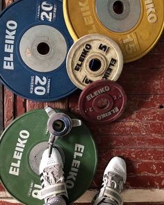 a person standing on top of a pair of shoes next to two different colored discs