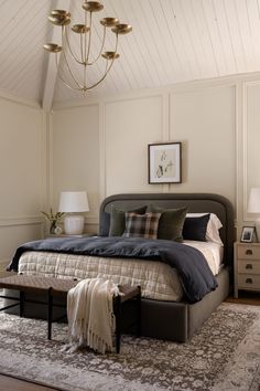 a bedroom with a large bed and chandelier hanging from it's ceiling