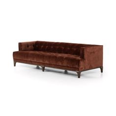 a brown velvet couch with wooden legs