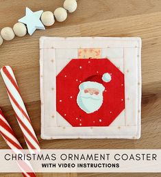 christmas ornament coaster with video instructions on wood table next to candy canes