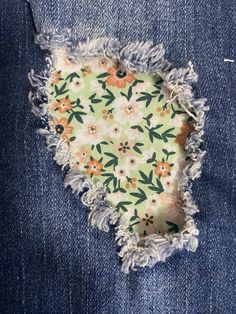 an old pair of jeans with torn edges and flowers on them