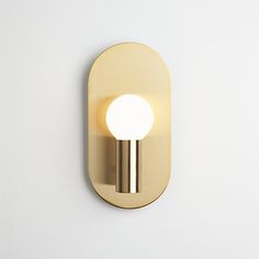 a light that is on the wall next to a white wall with a round object in it