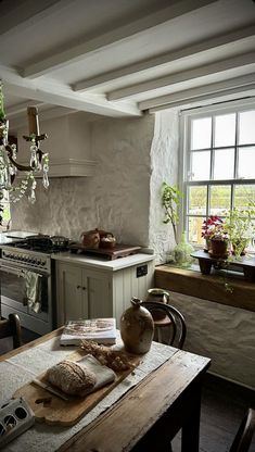 a kitchen with an old fashioned table and chandelier hanging from the ceiling above it