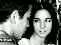 black and white photograph of a man and woman looking at each other in front of bookshelves