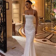 a woman in a white wedding dress standing next to a doorway