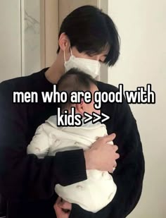 a man holding a baby wearing a face mask with the words men who are good with kids > >