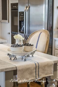 two bowls with flowers are sitting on a table in the middle of a kitchen area