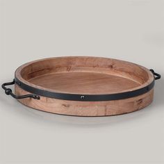 a round wooden tray with black handles