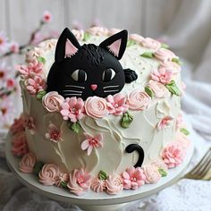 a cake decorated with flowers and a black cat