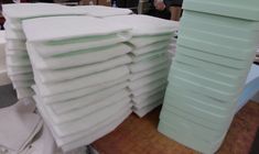 stacks of folded white paper sitting on top of a wooden table next to each other