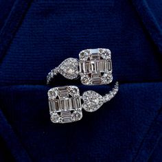 two diamond rings sitting on top of a blue cloth