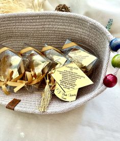 a basket filled with lots of small pieces of gold foil and tasseled tags