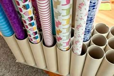 several rolls of wrapping paper sitting on top of a wooden stand next to each other