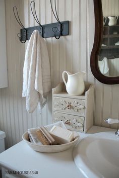 a white sink sitting under a mirror next to a towel rack