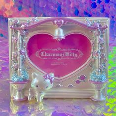 a hello kitty figurine sitting in front of a heart shaped frame with the name charmmy kitty on it